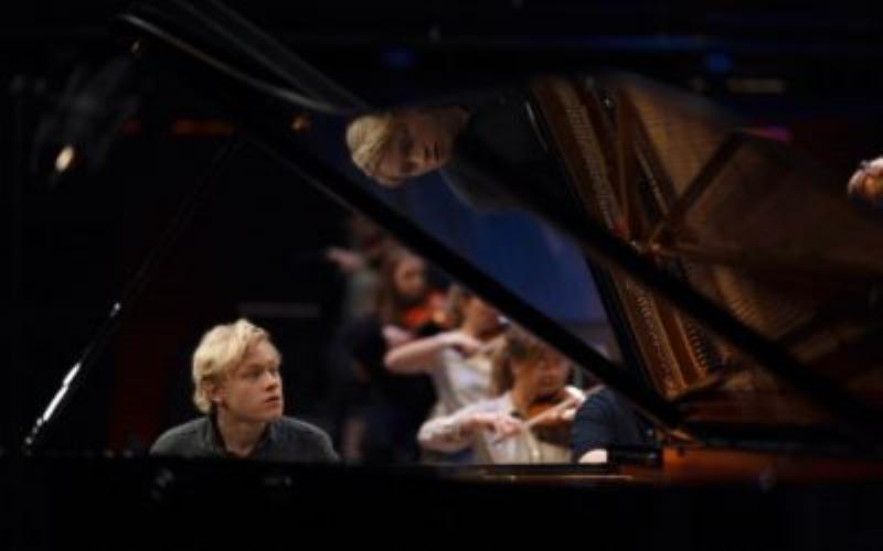 Une scène éclairée du festival Roque d’Anthéron avec un piano de concert sous les platanes, ambiance magique